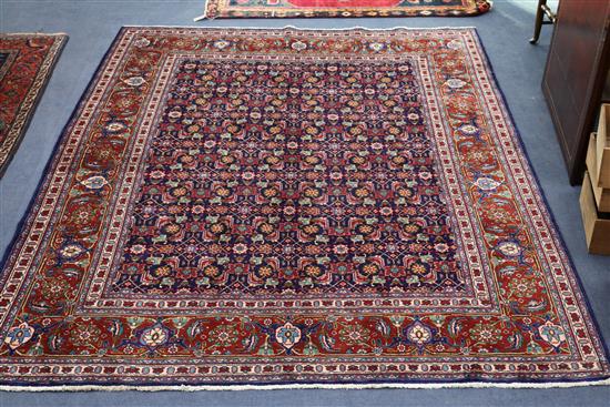 A Tabriz red and blue ground rug, 9ft 5in by 6ft 10in.